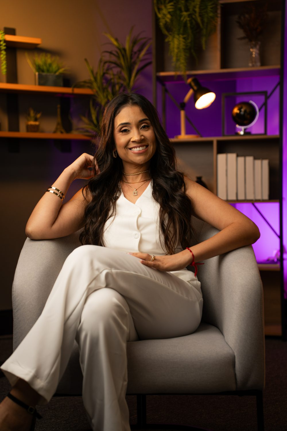 Retrato de Mariana Oliveira sentada, sorrindo, em ambiente de escritório